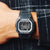 Zegarek męski Casio G-Shock na nadgarstku z czarnym paskiem i wyświetlaczem cyfrowym