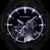 Tarcza zegarka Casio G-Shock z ciemną powierzchnią i fioletowymi akcentami w nocnym podświetleniu