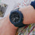Zegarek męski Casio G-Shock na nadgarstku, widoczny niebieski pasek i czarna tarcza